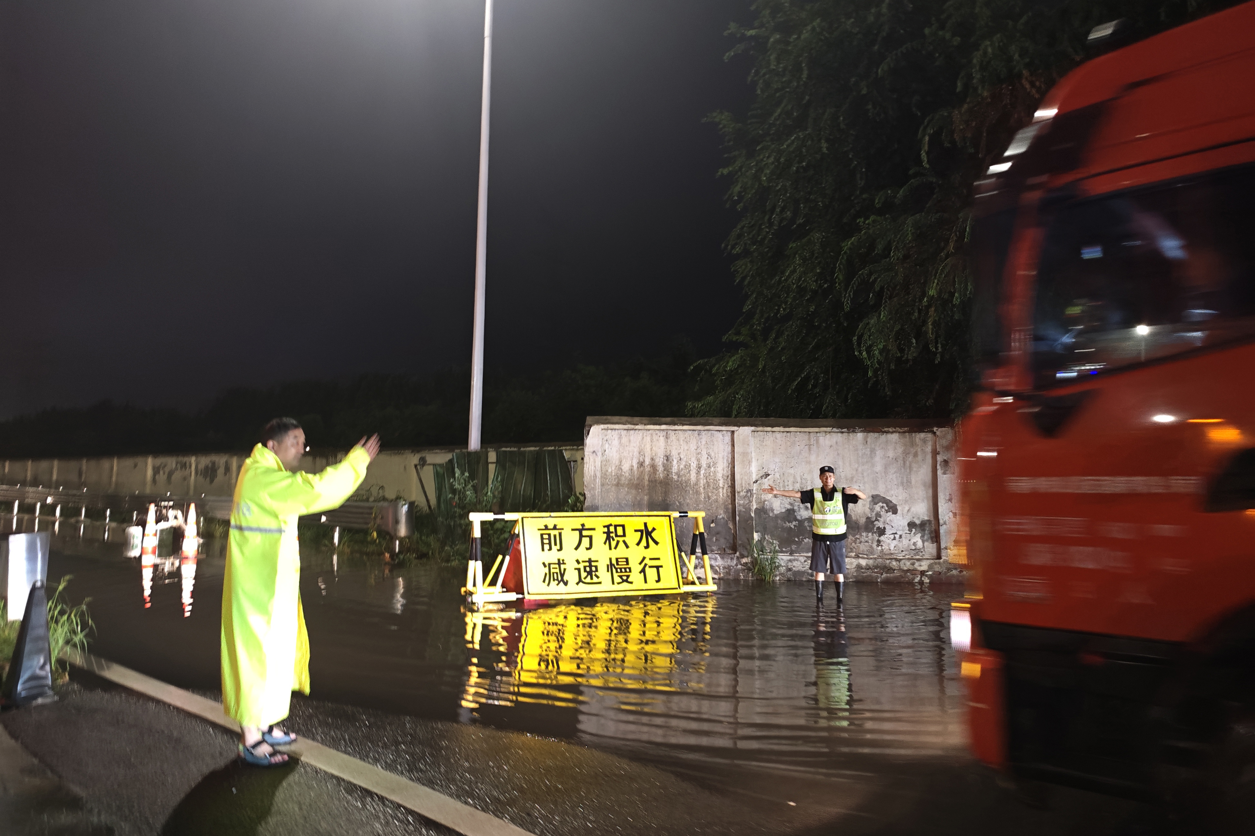 7月15日晚，2050分，鄭州東服務(wù)區(qū)監(jiān)管辦主任帶領(lǐng)值班人員冒雨排查積水點抽水作業(yè)，并指揮車輛順利通行。（攝像：王雅13949144133）.jpg